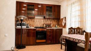 a kitchen with wooden cabinets and a stove top oven at Syune House in Tatʼev