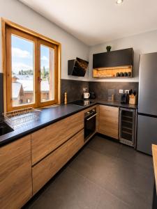 a kitchen with wooden cabinets and a large window at *** Le Refuge *** Logement standing Megève in Demi-Quartier