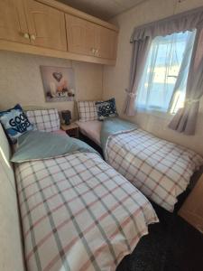 a bedroom with two beds and a window at Mark and Teresa's 8 berth caravan on Coral Beach Ingoldmels in Ingoldmells