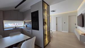 a kitchen with a table and a dining room at Apartman Premium Posušje in Posušje