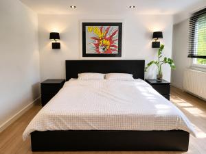 a bedroom with a large bed and two night stands at B&B The Parklane Retreat in Schoten