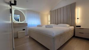 a bedroom with a large white bed and a mirror at Apartman Premium Posušje in Posušje +11 photos