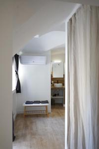 a white hallway with a bench in a room at Le Loft in Sainte Anastasie - Aubarne