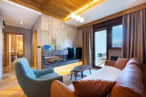 a living room with a couch and a fireplace at MonteBreza Spa Apartment Jacuzzi, Sauna & Free Parking in Kolašin +44 photos