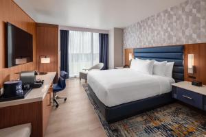 a hotel room with a large bed and a desk at Hollywood Casino & Hotel Columbus in Columbus