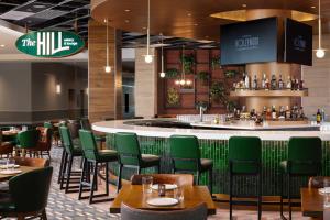 a restaurant with green chairs and a bar at Hollywood Casino & Hotel Columbus in Columbus