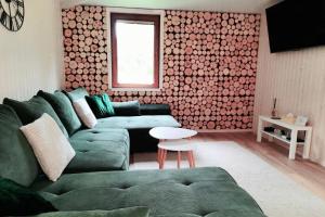 a living room with a green couch and a table at Kabakėlio slėnis in Kabakelis