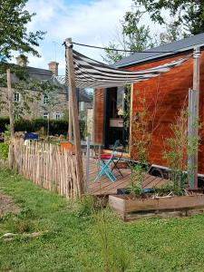 a hammock on a deck in front of a house at entre bourg et rivage in Saint-Pierre-Langers