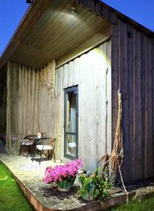 a wooden building with flowers on a patio at Imantass in Salacgrīva