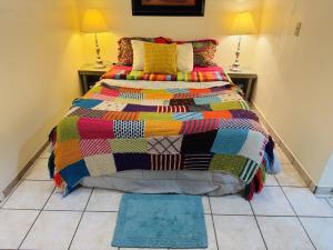 a bed with a colorful quilt on it in a room at Ocean Light at Villa Hermosa in San Carlos