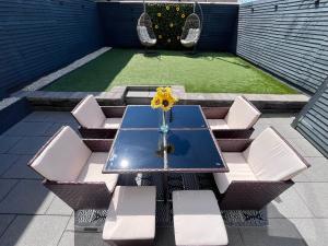 a table with white chairs and a vase with a sunflower at The Earls in Newry