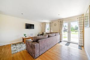 a living room with a couch and a tv at Sage Lodge in Brigg