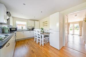 a kitchen with a table and a white refrigerator at Sage Lodge in Brigg