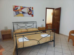 a bedroom with a bed and a painting on the wall at IL MELOGRANO Rooms in Vignacastrisi