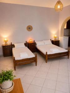 a room with two beds and a table with two lamps at Natasa studios Kythera in Kythira +6 photos