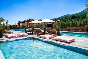 a swimming pool with pillows and chairs next to at Premier Luxury Mountain Resort in Bansko