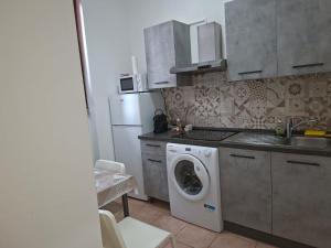 a kitchen with a washing machine and a refrigerator at Jessy house in Cantù