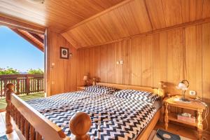 a bedroom with a bed with a wooden wall at Pool Chalet Adonis w/ Panoramic Views - Happy Rentals in Semič