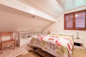 a bedroom with a bed and a chair and a window at Pool Chalet Adonis w/ Panoramic Views - Happy Rentals in Semič