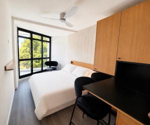 a hotel room with a bed and a desk and a television at Sweetly La Rochelle in La Rochelle