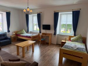 a living room with two beds and a table at Hotel Atawa in Raby