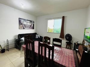 a living room with a couch and a table and chairs at Apto c TV Streaming Ar Wifi e Piscina in Ananindeua