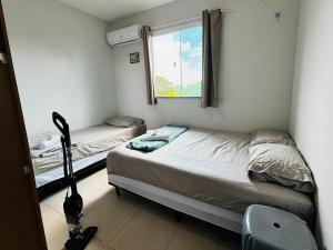 a small bedroom with two beds and a window at Apto c TV Streaming Ar Wifi e Piscina in Ananindeua +13 photos