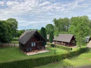an aerial view of a wooden house in a field at Domaine de Guillaume Chalet 4 Pers in Auquainville