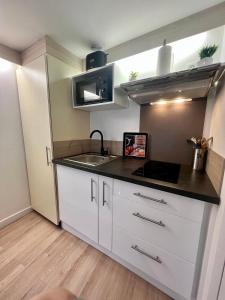 a kitchen with a sink and a counter top at Etablissement Cloutiers comprenant plusieurs logements de type studio - Hyper Centre Brive in Brive-la-Gaillarde