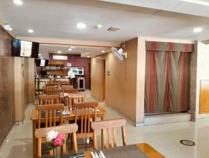 a restaurant with tables and chairs and a chef in the kitchen at Hotel Regis in Mexicali