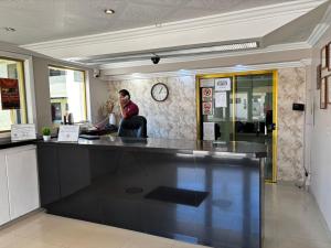 a man sitting at a counter in a restaurant at Hotel Regis in Mexicali