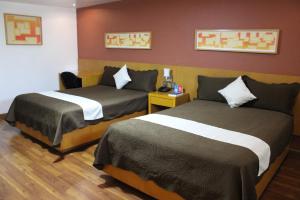 a hotel room with two beds in a room at Hotel Regis in Mexicali