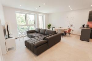 una sala de estar con un sofá y una mesa en Genuss Apartment Basic, en Purbach am Neusiedlersee