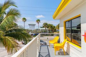 a balcony with yellow chairs and a view of the beach at Sunset Inn and Cabanas in St. Pete Beach