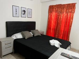 a bedroom with a black bed and a red curtain at HSR Termas in Termas de Río Hondo