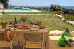 a table with food and wine glasses and a pool at Agriturismo La Quercia Bella in Collazzone