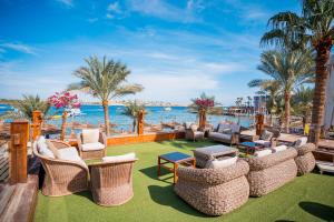 a patio at the beach with chairs and tables at Marina Sharm Hotel in Sharm El Sheikh