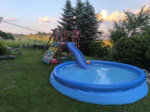 a blue pool with a slide and a playground at Pokoje Janka Gliczarów Górny in Gliczarów