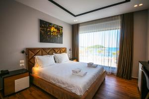 a bedroom with a bed with a view of the ocean at King Hotel Ksamil in Ksamil