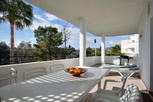a table with a bowl of fruit on a balcony at Sunny Golf Apartment in Estepona