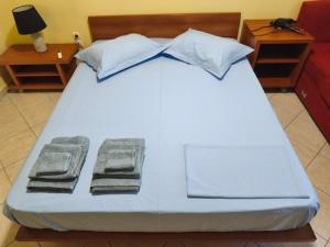 a large white bed with two towels on it at Vania's apartment in Preveza