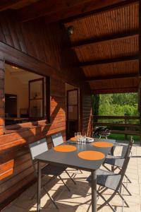 a patio with a table and chairs on a house at Domaine de Guillaume Chalet 4 Pers in Auquainville