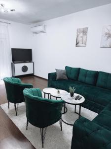a living room with a green couch and chairs at M&M Trebinje in Trebinje