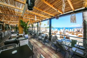 a restaurant with tables and chairs and a view of the ocean at King Hotel Ksamil in Ksamil