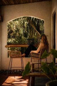 a man sitting in a chair in front of a window at Believe Surf & Yoga Lodge Santa Teresa in Santa Teresa Beach +106 photos