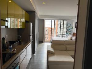 a kitchen with a couch and a bed in a room at Loft Cool Equilibrium in Bogotá