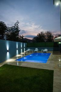 a swimming pool in a backyard at night at Antonelya Home in Sapanca