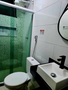 a bathroom with a shower and a toilet and a sink at Pousada Belezinha in Arraial do Cabo +51 photos