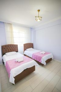 a room with two beds with pink and white sheets at Antonelya Home in Sapanca