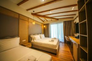 a hotel room with two beds and a desk at Hotel Lake Park Ksamil in Ksamil +88 photos